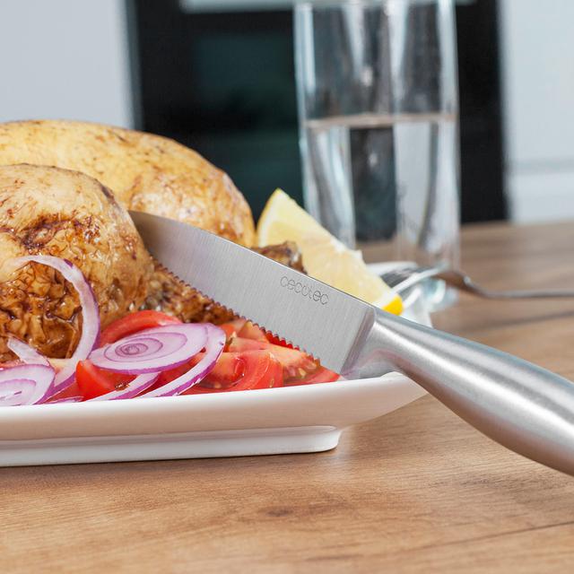 Cuchillo Cecotec de carne con hoja serrada cortando carne