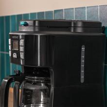 Coffee 66 Grind & Drop Macchina da caffè americano da 12 tazze con rifiniture in acciaio inossidabile e intensificatore di aroma. Cafetière numérique idéale pour remplir 12 tasses avec une finition en acier inoxydable et un intensificateur d’arômes. Digitaler Filterkaffeemaschine für 12 Tassen mit Edelstahl-Finish. Máquina de café de filtro, para 12 chávenas, com acabamentos em aço inoxidável e intensificador de aroma.