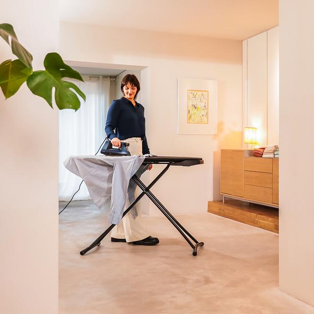 Plancha CECOTEC IronHero 3000 Sauna i-Pump en uso sobre tabla de planchar