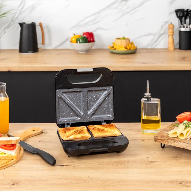 A máquina de fazer 2 sanduíches Rock'nToast Classic + com acabamento em aço inoxidável, 800 W de potência e placas triangulares com revestimento antiaderente.