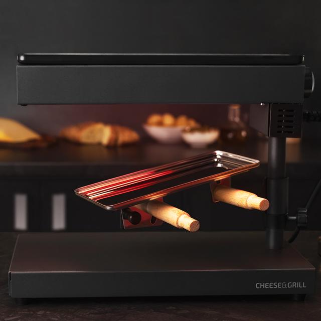 Raclette Cheese&Grill 6000 Black. 600 W de puissance, fonction Gril, finition en acier inoxydable, thermostat réglable, 2 spatules en bois, gril supérieur antiadhésif, gril supérieur antiadhésif