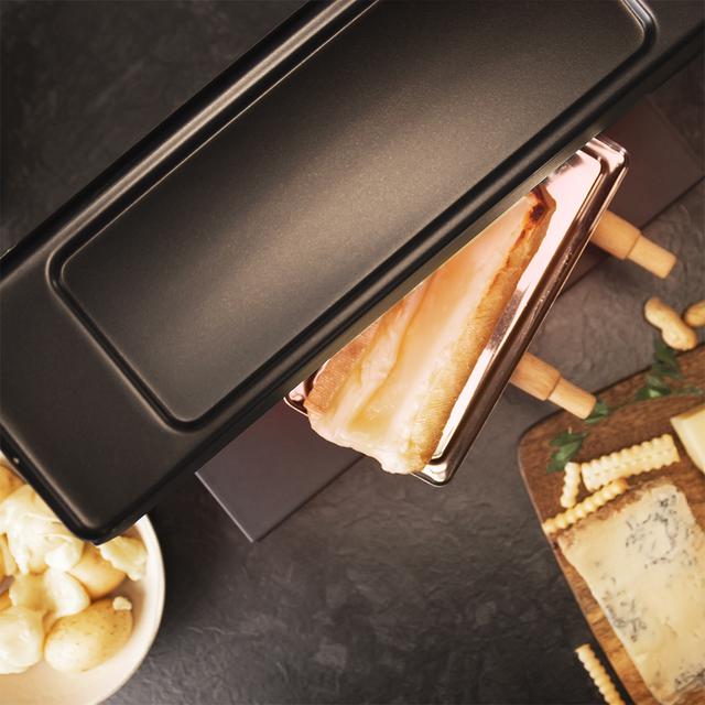 Raclette Cheese&Grill 6000 Black. 600 W de puissance, fonction Gril, finition en acier inoxydable, thermostat réglable, 2 spatules en bois, gril supérieur antiadhésif, gril supérieur antiadhésif