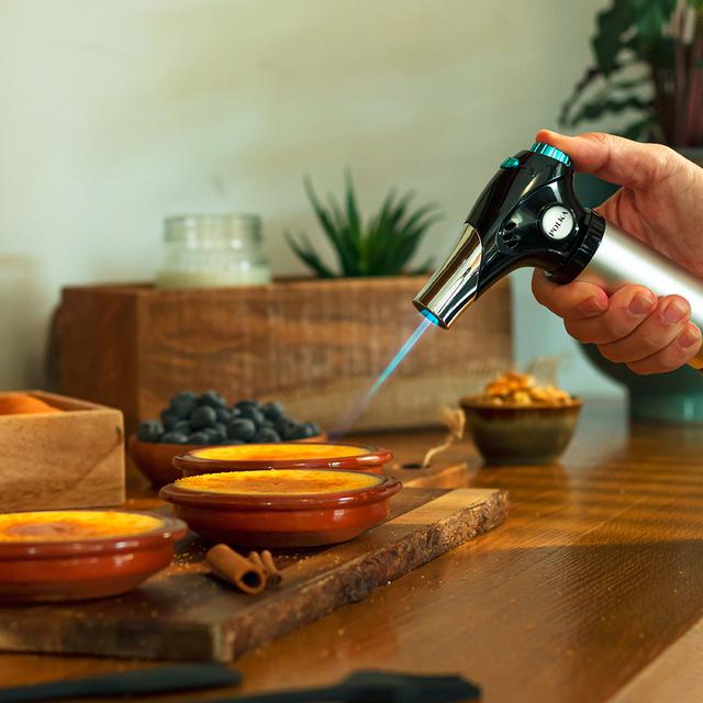 Polka Flame-Cook 1000 Steel Wiederaufladbare Küchenfackel mit Flammenregulierung, die bis zu 1300 Grad erreicht. Durch seine kompakte Bauweise ist er einfach zu bedienen und leicht zu verstauen. Inklusive Pinsel, Spatel und Rezeptheft.