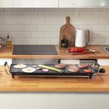 Plancha électrique Tasty&Grill 3000 RockWater XL. 2400 W de puissance, grande surface de 70 x 22 cm, revêtement antiadhésif en pierre RockStone et thermostat réglable.