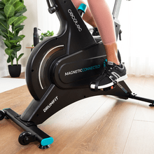 Drumfit Indoor 10000 Magnetic Connected Bicicleta indoor de resistencia magnética con volante de inercia de 10 kg, resistencia magnética, APP, pantalla LCD, pulsómetro, ruedas de transporte y soporte para tablet. Peso máximo de 120 kg y altura máxima 185 cm.