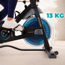 Bicicleta giratória interna DrumFit 13000 Race com volante de 13 kg. Ecrã LCD. Dispositivo e porta-garrafa. Rodas de transporte. Sela ajustável vertical e horizontalmente. Peso máximo 120 kg e altura máxima 190 cm.