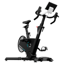 DrumFit Indoor Professional Incline Bicicleta indoor profesional con resistencia magnética e inclinación motorizada. APP. Volante de inercia 10 Kg aluminio. 16 niveles de inclinación. 32 niveles de resistencia. Ruedas de transporte. Soporte para dispositivos. Peso máximo de 110 kg y altura máxima 190 cm.