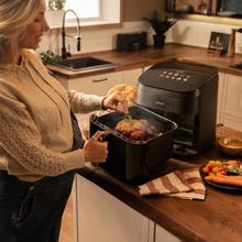 Cecofry&Grill Smokin' 8500 Friggitrice ad aria con doppia resistenza e funzione affumicatore, ideale per una doratura uniforme e un autentico sapore di barbecue sulla carne. Con una capacità di 8,5 litri e una potenza di 2200 W, è perfetta per preparare piatti gustosi e salutari.