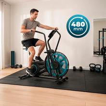 Drumfit WOD Rider 2000 Eolo PRO es una bicicleta de aire para entrenamientos intensivos, con ventilador de 480 mm y resistencia progresiva, pedaleo silencioso por correa, pantalla LCD, medidor de pulso en las asas, ruedas de transporte, compatibilidad y capacidad máxima de 135 kg.