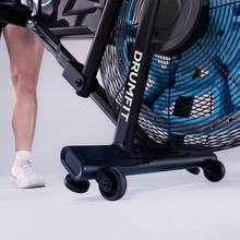 Drumfit WOD Rider 2000 Eolo PRO es una bicicleta de aire para entrenamientos intensivos, con ventilador de 480 mm y resistencia progresiva, pedaleo silencioso por correa, pantalla LCD, medidor de pulso en las asas, ruedas de transporte, compatibilidad y capacidad máxima de 135 kg.