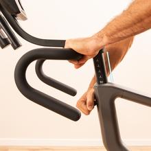 Drumfit indoor Ultra Riderdoor es una bicicleta de ciclo indoor de alto rendimiento equipada con un sistema de resistencia electromagnética pura de 32 niveles motorizados, volante de inercia de 9 kg y una consola LCD con 23 programas, diseñada para ofrecer un entrenamiento cardiovascular preciso, silencioso e interactivo en el hogar.