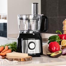 Robot culinaire Comino 1000 Spatula, 1000 W, 2 vitesses, fonction pulse, bol de 2 L. 3 disques de découpe : lame à hacher, lame à pétrir, disque à jus et disque à crémer. Corps en plastique et acier inoxydable.